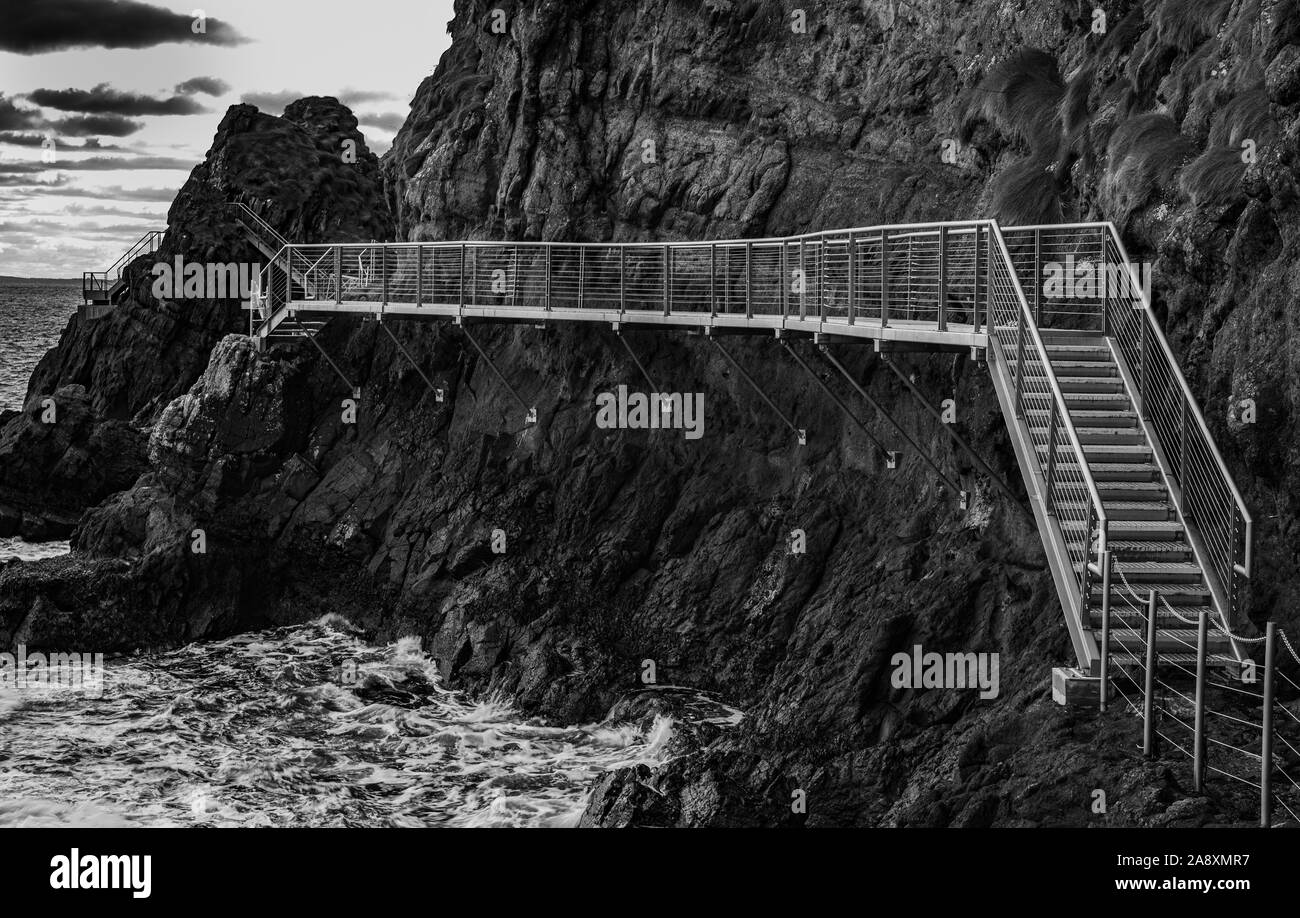 Il Gobbins drammatica ondata di schiantarsi sulla scogliera percorso a piedi sulla East Antrim costa Causeway percorso costiero, County Antrim, Irlanda del Nord Foto Stock