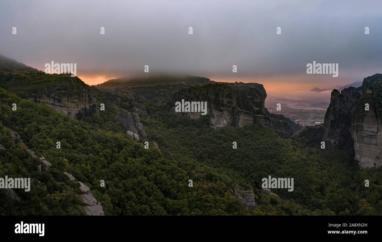Meteora incandescente sunrise con la Santa Trinità monastero sotto il soffitto di nebbia Foto Stock