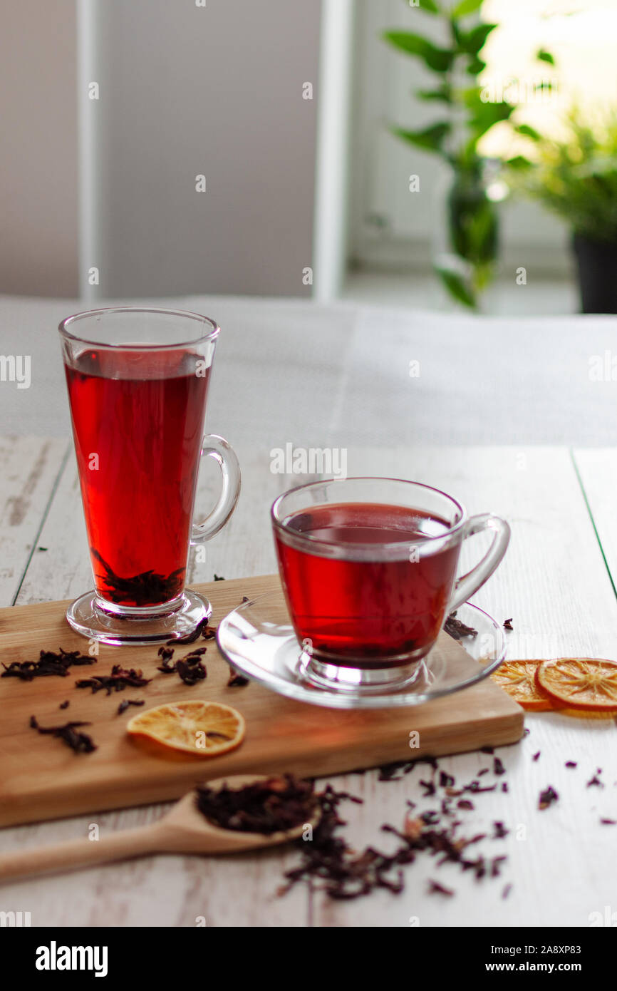 Tazza di tè di ibisco (karkade, rosso sorrel, Agua de Flor de Jamaica) su un tavolo. Bevanda fatta da magenta calyces (sepali) di Roselle fiori. Foto Stock