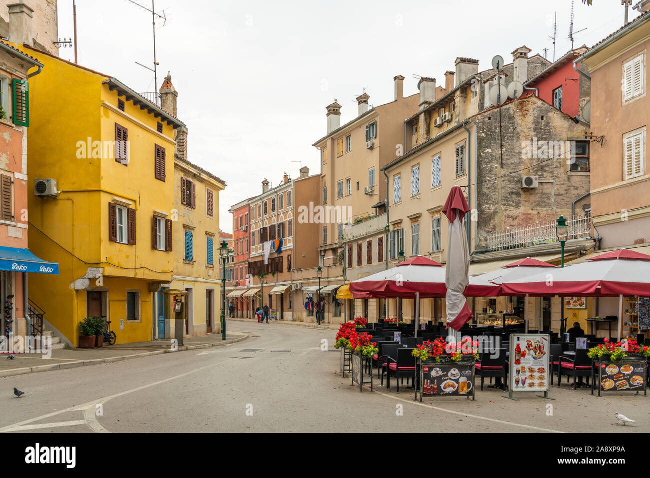 Una strada con i suoi edifici colorati e un ristorante all'aperto a Rovigno, Croazia, Istria. Foto Stock