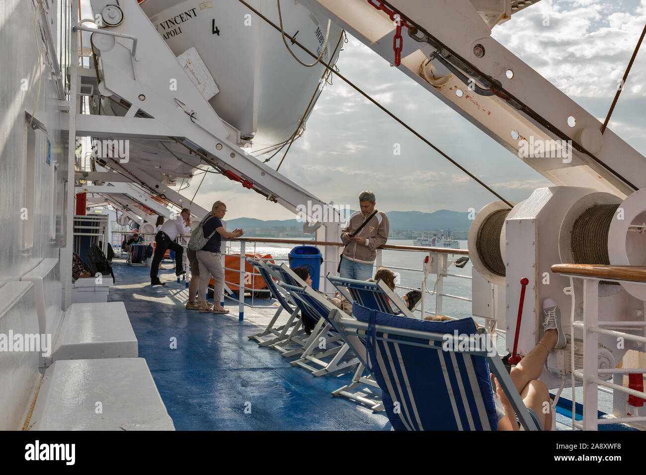 LIVORNO, Italia - Luglio 12, 2019: ai passeggeri di viaggiare sul ponte della nave Moby Vincent nave traghetto all'alba, Livorno in background. Moby è un italiano shippi Foto Stock
