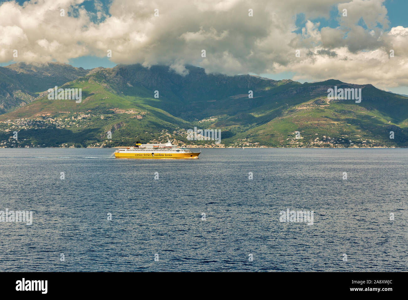 La CORSICA, Francia - Luglio 12, 2019: Corsica Ferries - Sardinia Ferries nave a vela in mare con enormi nuvole. Si tratta di una compagnia di traghetti che opera Foto Stock