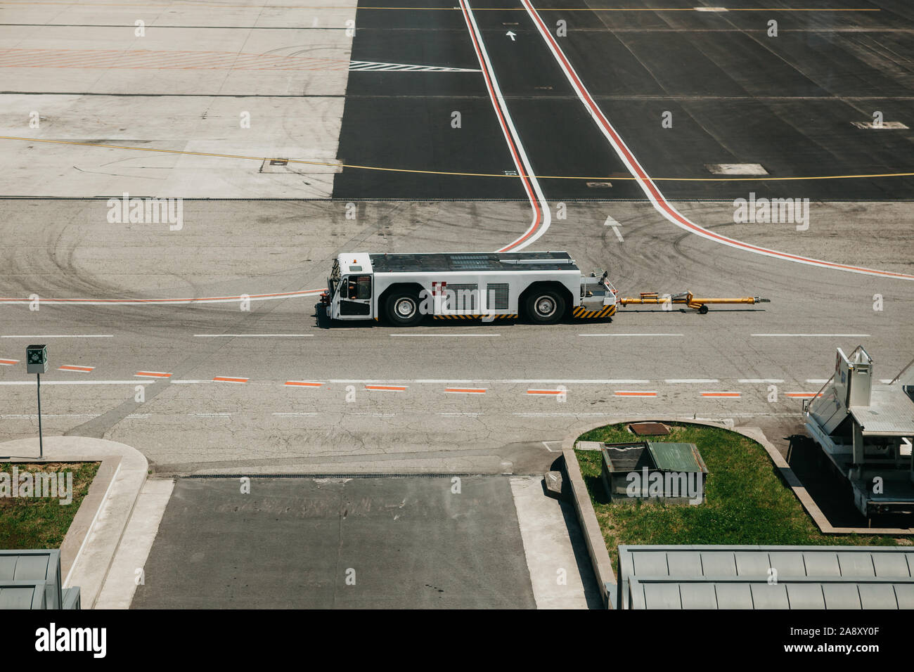 Airfield trattore corse su strada presso l'aeroporto Foto Stock