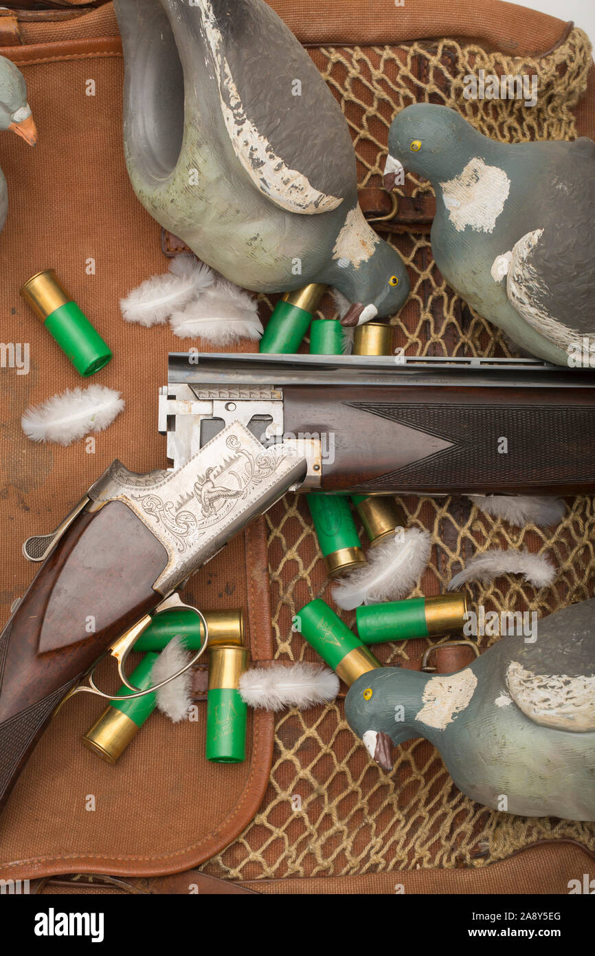 Un studio fotografia di un Browning B125 12-foro al di sopra e di sotto il fucile. Si vede qui in appoggio su un vecchio gamebag con 12-foro munizioni, Piccione di legno Foto Stock
