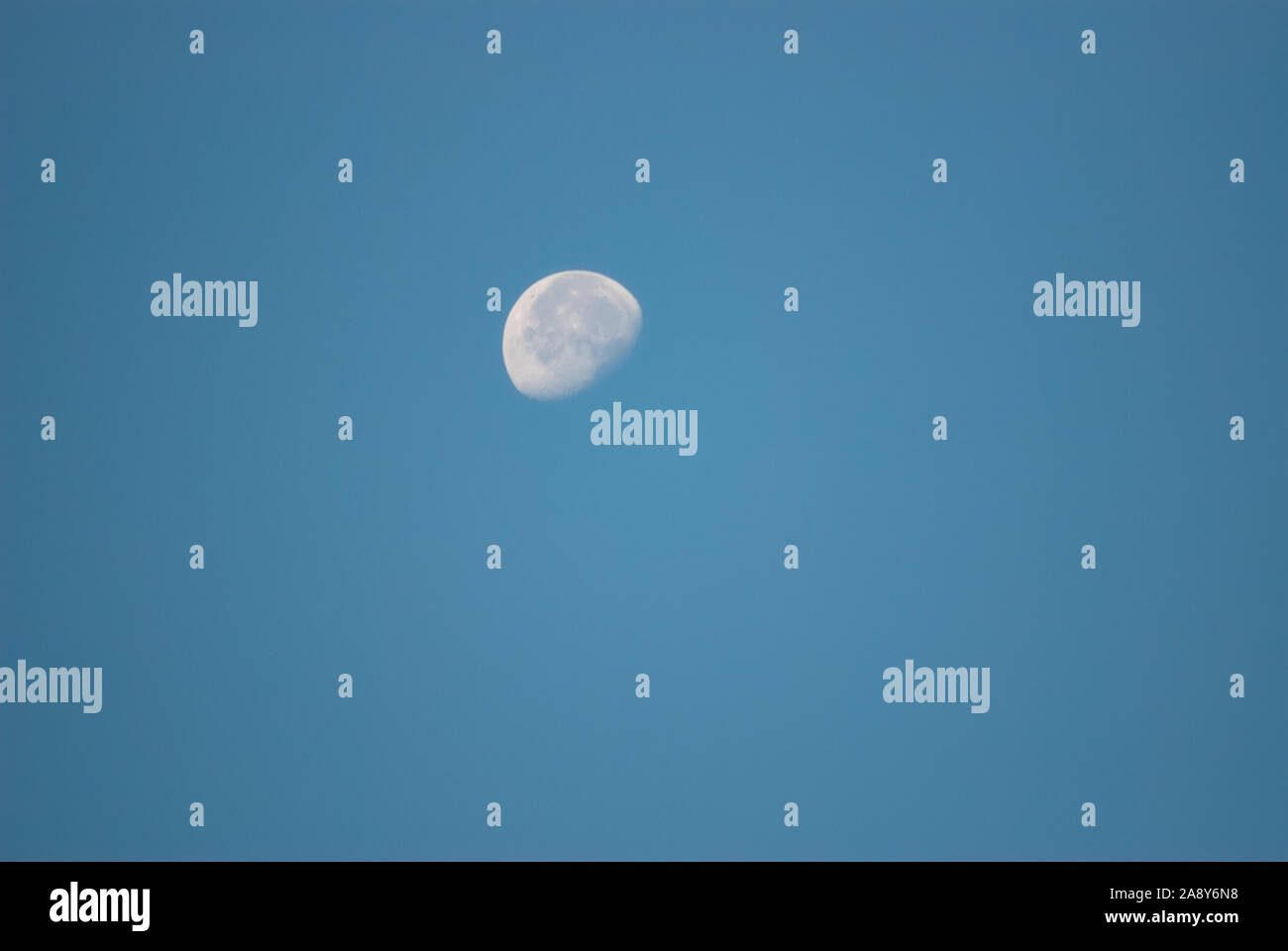 Bianco brillante luna contro il cielo blu Foto Stock