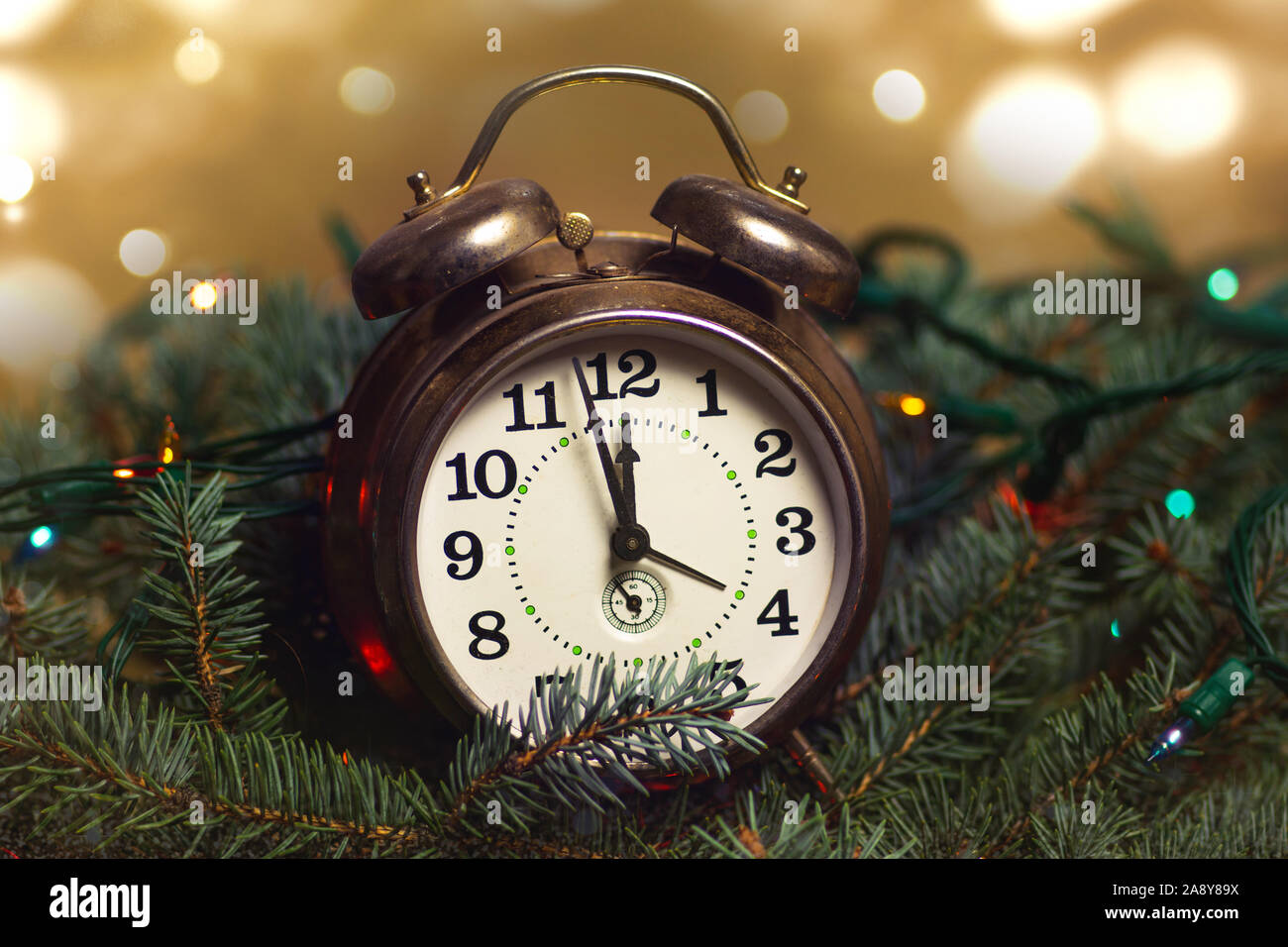 Orologio Vintage avvicina mezzanotte ora e albero di Natale luci Foto Stock