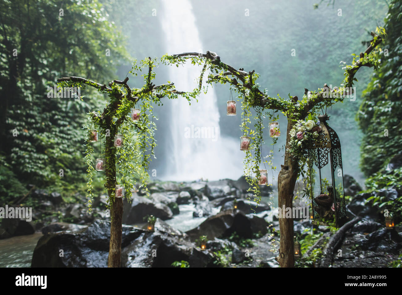 Insolita cerimonia di nozze arch con cascata vista nella giungla foresta pluviale. Sogno di cerimonia nuziale di Bali. Foto Stock