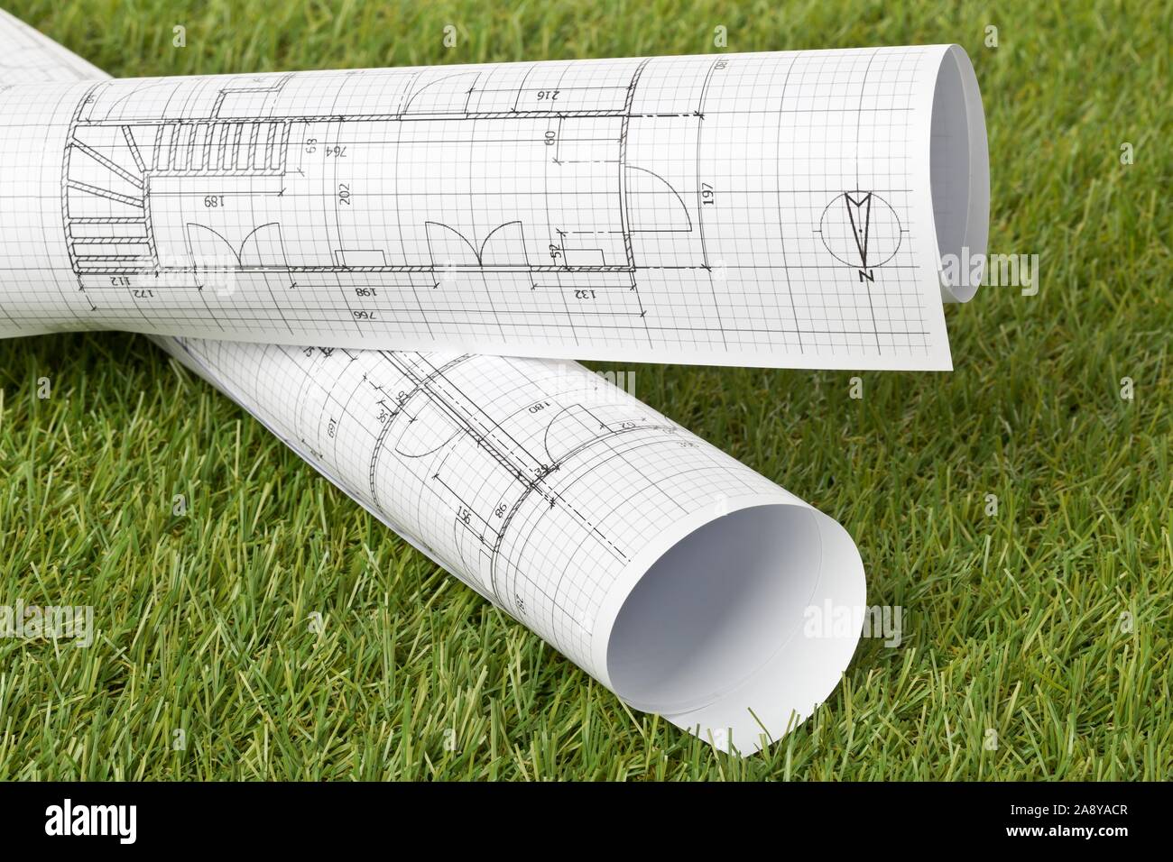 Gli schemi architetturali sul verde prato di sfondo - della costruzione o acquisto di concetto, il fuoco selettivo Foto Stock