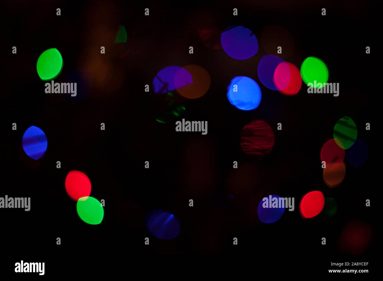 Defocalizzata colorate luci di Natale su albero di Natale sfondo scuro Foto Stock
