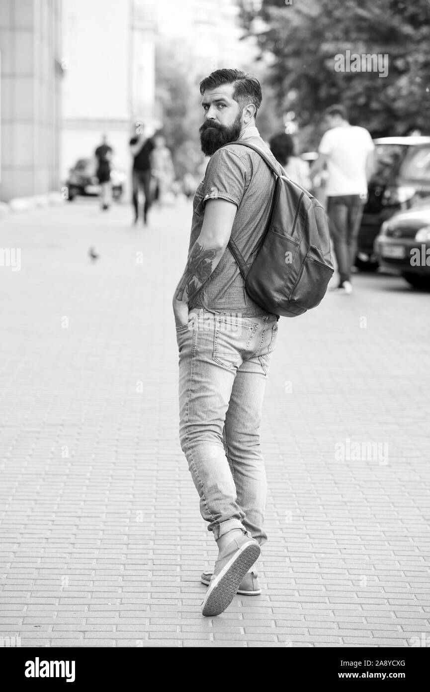 La vacanza estiva. Concetto di sightseeing. Zaino per il viaggio urbano. Hipster indossando uno zaino strada urbana dello sfondo. Uomo Barbuto viaggiare con lo zaino. Guy esplorare la città. Turismo confortevole. Foto Stock
