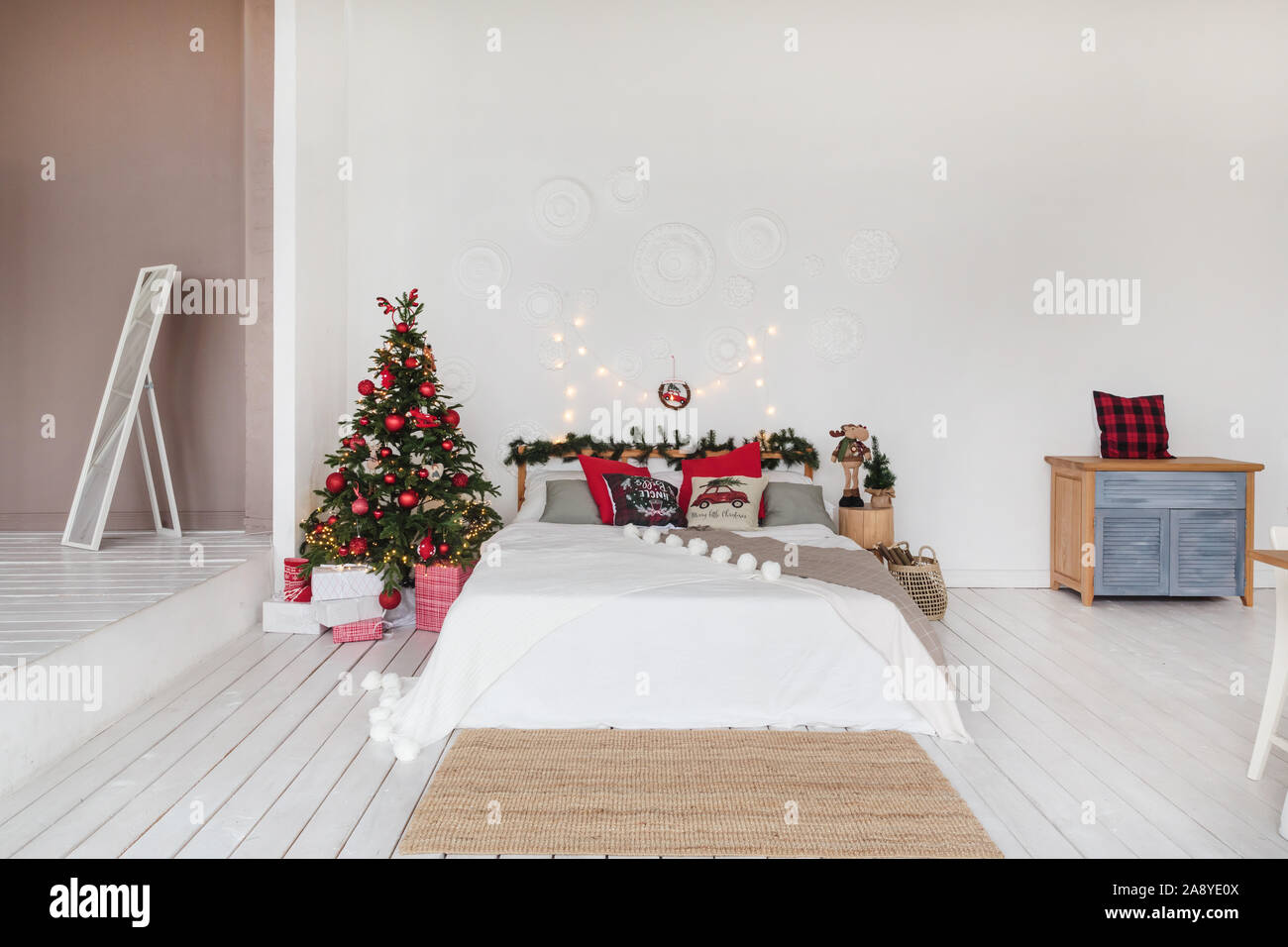Bianco in stile loft camera da letto rosso con decorazioni di Natale. Foto Stock