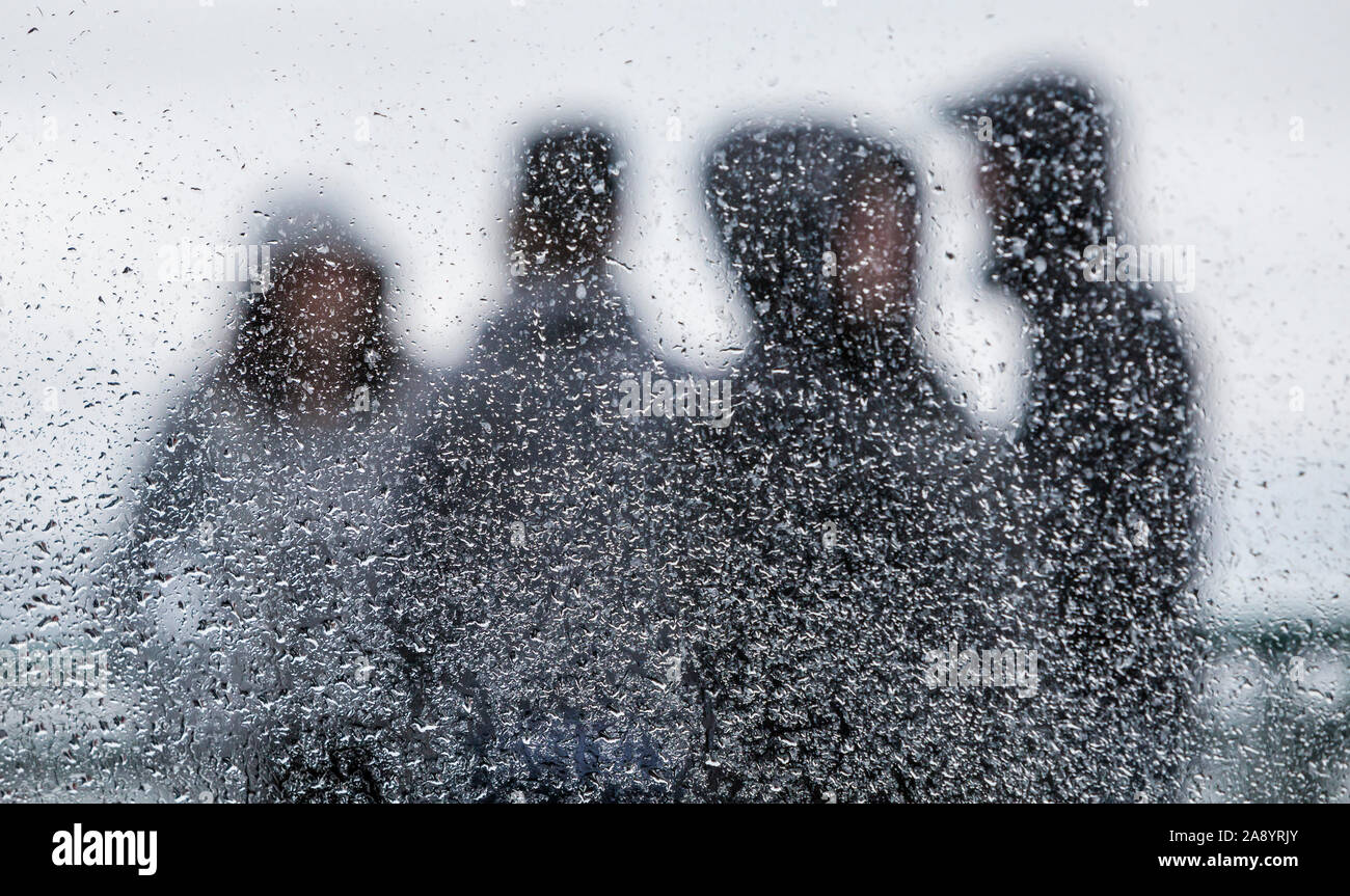 Persone in piedi sulla piattaforma esterna su un stato di Washington in traghetto la pioggia visibile attraverso una finestra coperta con gocce di pioggia, concentrarsi sulle gocce di pioggia. Foto Stock
