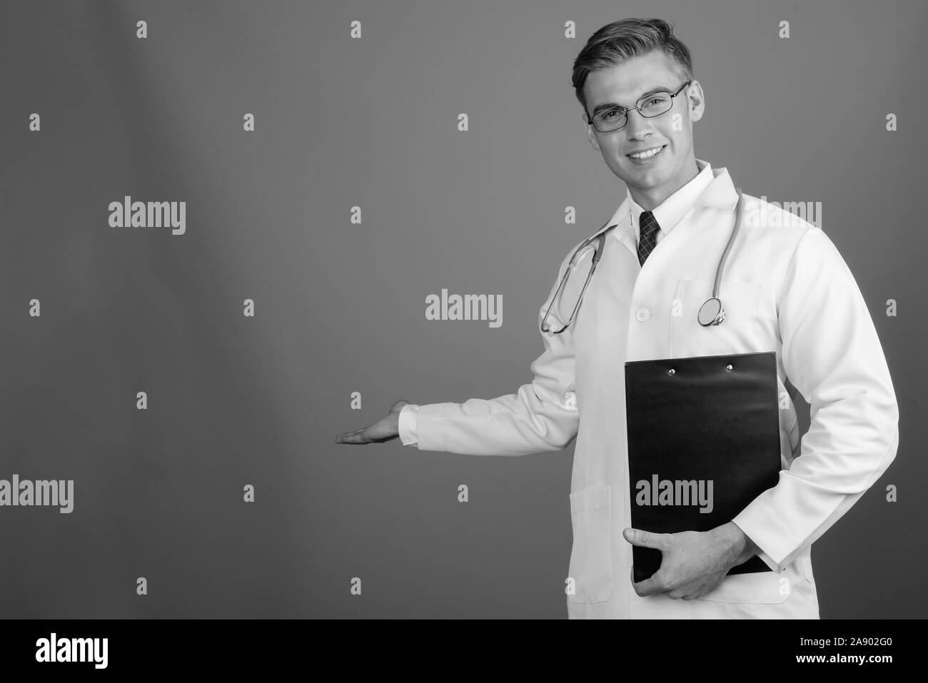 Ritratto di giovane uomo bello medico con gli occhiali in bianco e nero Foto Stock