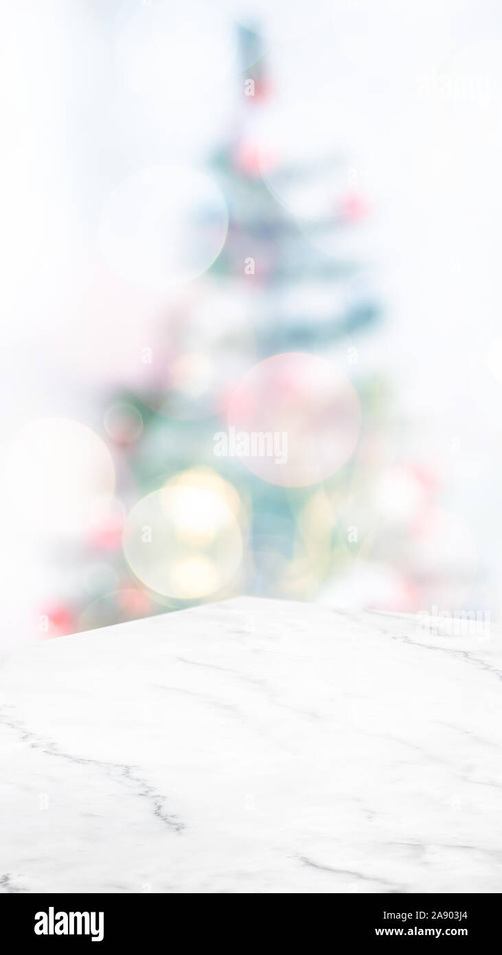 Vuoto in marmo bianco tavolo astratto con albero di Natale decorazioni luce stringa blur sullo sfondo,sfondo vacanze,Mockup banner verticale per la visualizzazione del parametro PR Foto Stock