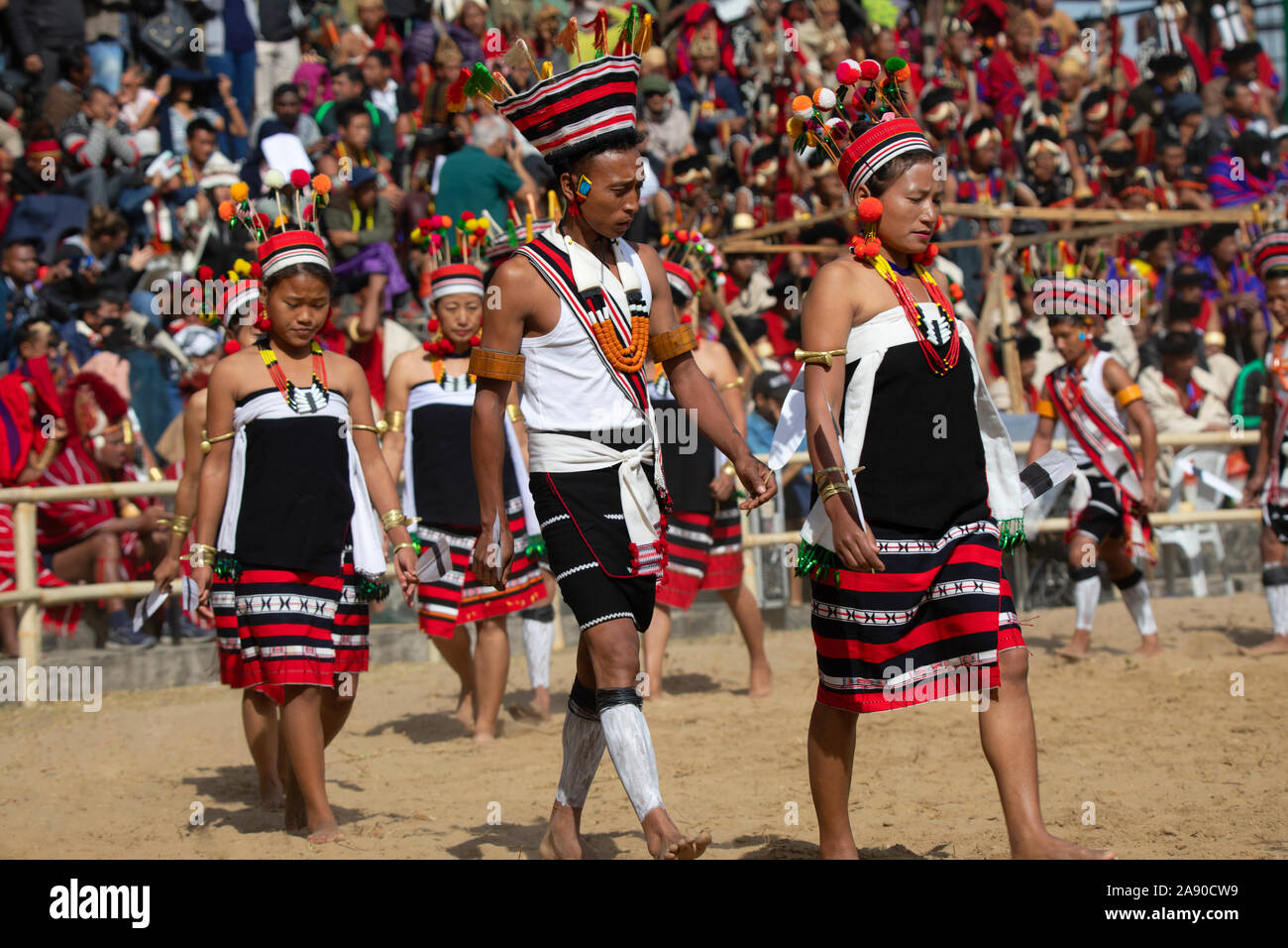 KISAMA, Nagaland, INDIA, dicembre 2018, tribù Angami giovani uomini e donne che danzano al Festival di Hornbill Foto Stock