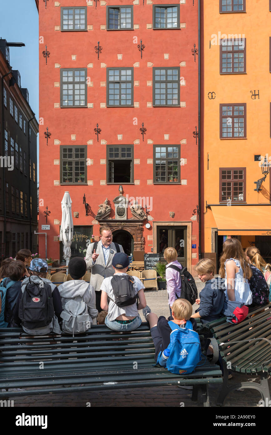 La scuola dei bambini della Scandinavia,vista di giovani studenti in ascolto al loro insegnante durante una gita al centro storico di Gamla Stan area di Stoccolma, Svezia Foto Stock