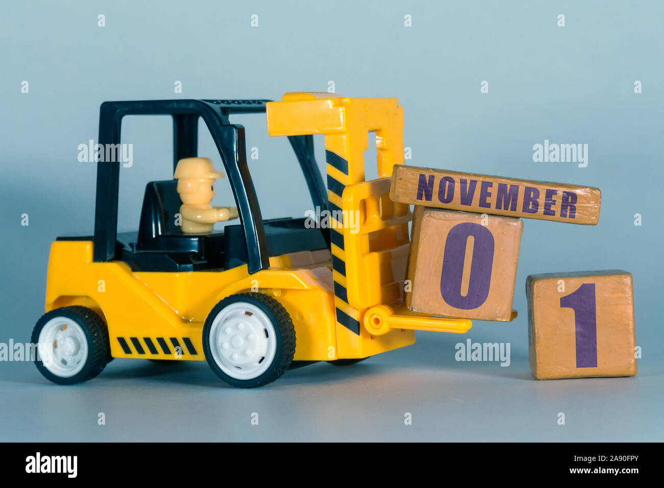 Novembre 1st. Il giorno 1 del mese, costruzione o magazzino calendario. Giocattolo giallo carrello carico di cubi di legno con data. Attività di pianificazione e gestione del tempo. au Foto Stock