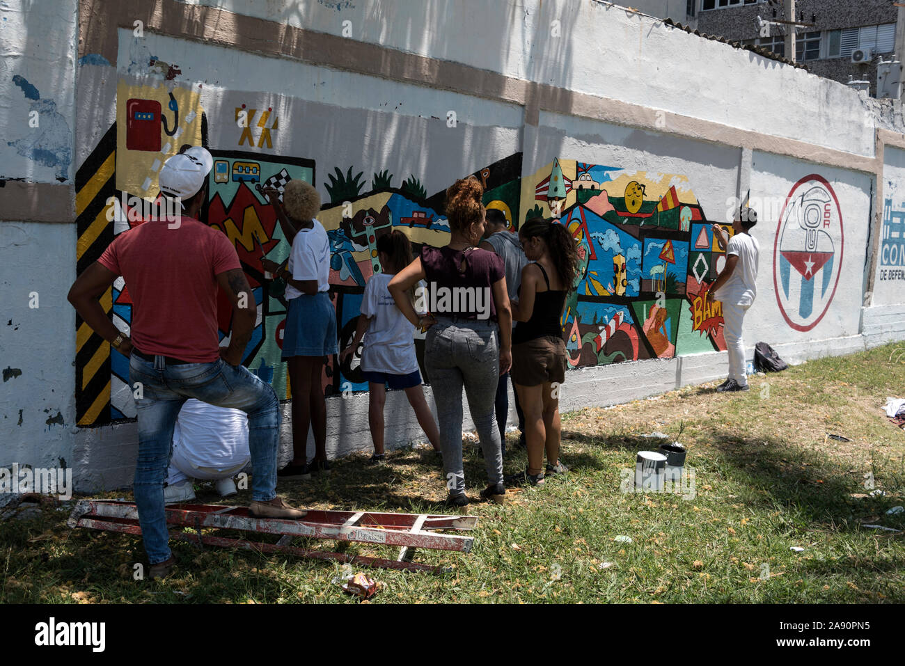 Un gruppo di giovani artisti pittura un muro in Salvador Allende/ Conill a l'Avana, Cuba Foto Stock