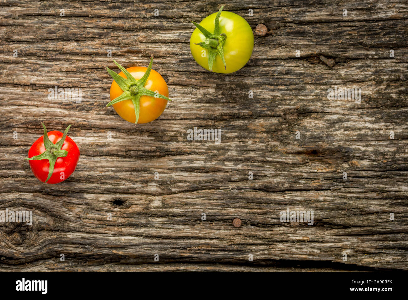 Pomodori colorati su una superficie in legno vicino. Un sano cibo biologico. Foto Stock