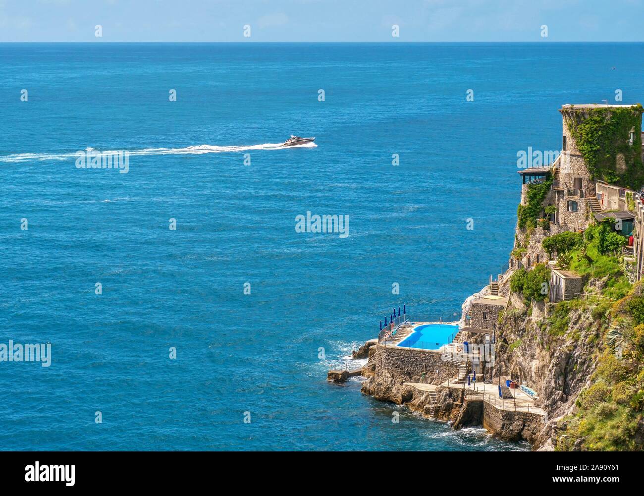 Vista drone di edifici in armonia con la ripida cliffside sulla Costiera Amalfitana, una località turistica di destinazione. Foto Stock