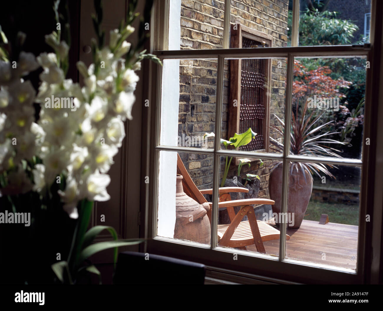 Vaso di stock bianco accanto alla finestra con vista del cortile townhouse Foto Stock