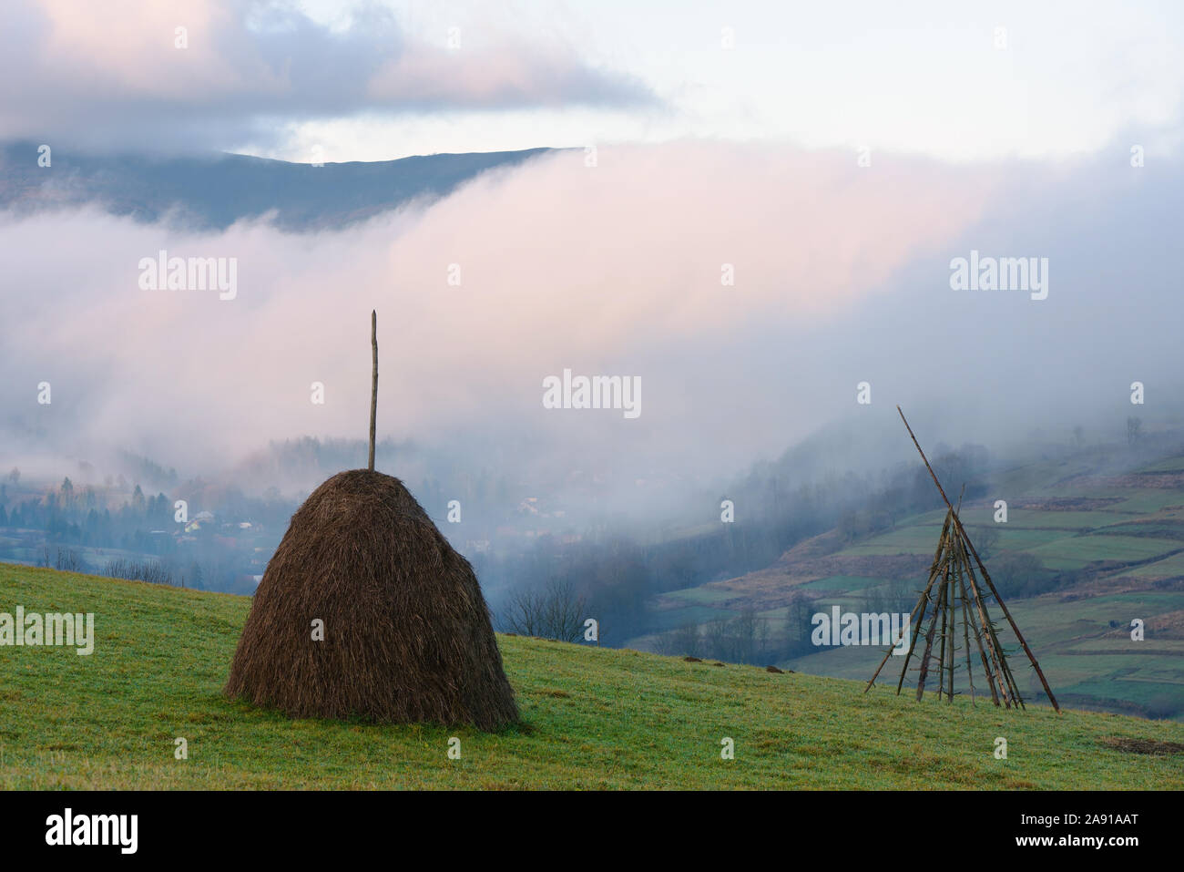 Pagliaio su un prato di montagna. In autunno la nebbia in montagna. Paesaggio rurale un giorno nuvoloso. Carpazi, Ucraina, Europa Foto Stock