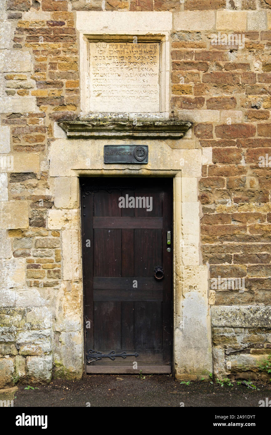 Segno e peste iscrizione sopra porta di legno vecchio edificio scolastico circa 1584 è stata restaurata nel 1994. Oakham, Rutland, Inghilterra, Regno Unito, Gran Bretagna Foto Stock