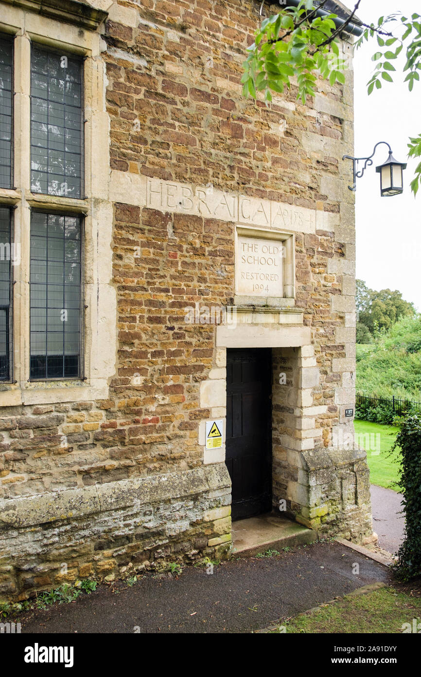 Segno e iscrizione sopra la porta del vecchio edificio di pietra scuola circa 1584 è stato restaurato nel 1994. Oakham, Rutland, Inghilterra, Regno Unito, Gran Bretagna Foto Stock