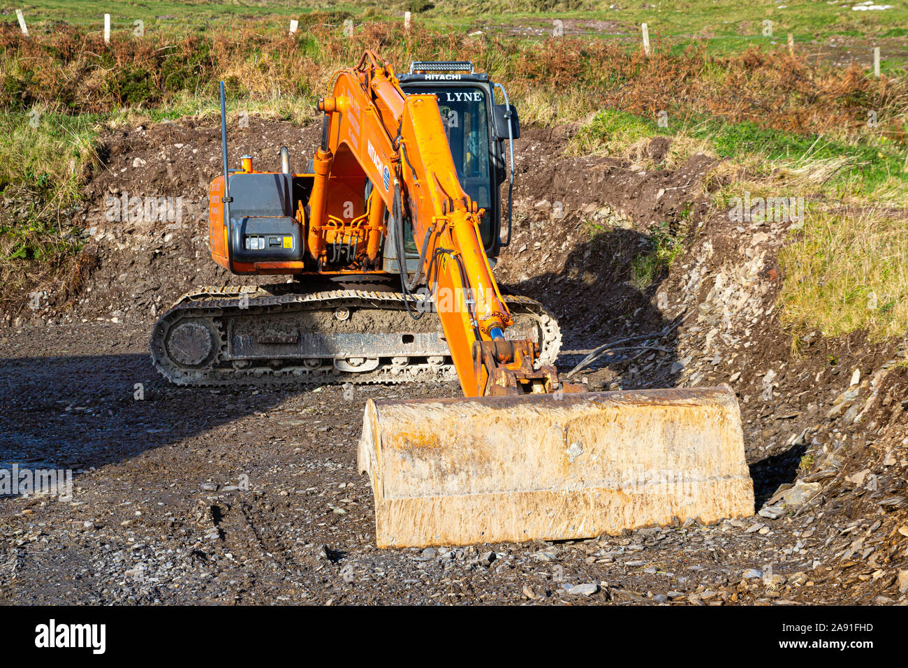 Terreno di scavo sul retro della casa privata con un bulldozer, a livello del suolo per il drenaggio Foto Stock