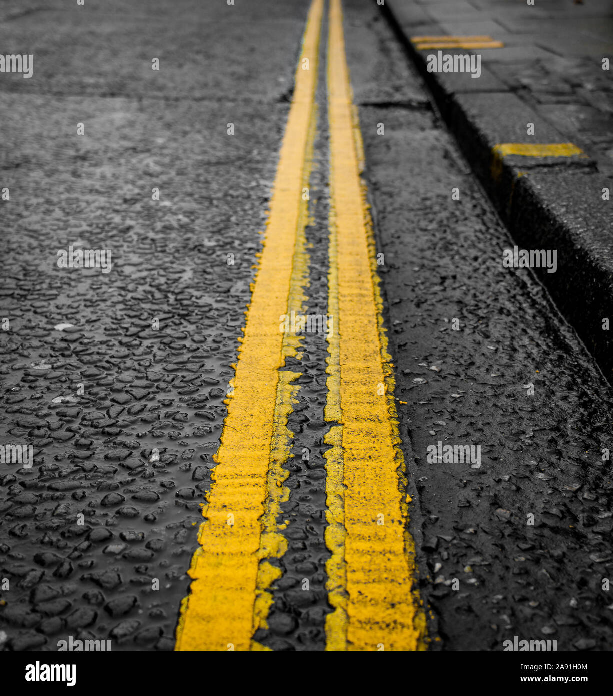 Parcheggio limitato, Close Up doppia luminosa linee di colore giallo su fondo bagnato e Rainy day - Norwich, Regno Unito Foto Stock