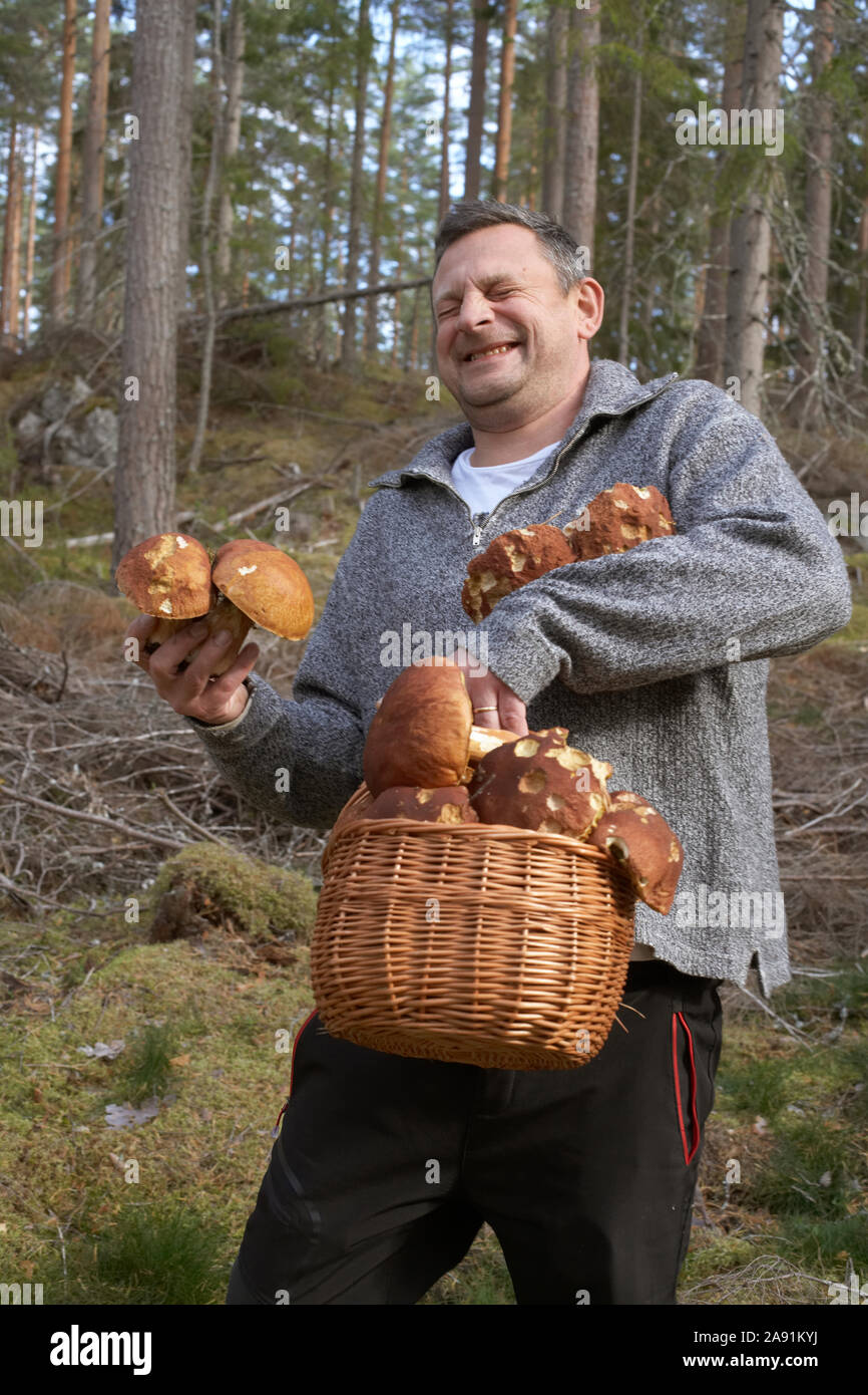 Uomo felice la raccolta di funghi Foto Stock