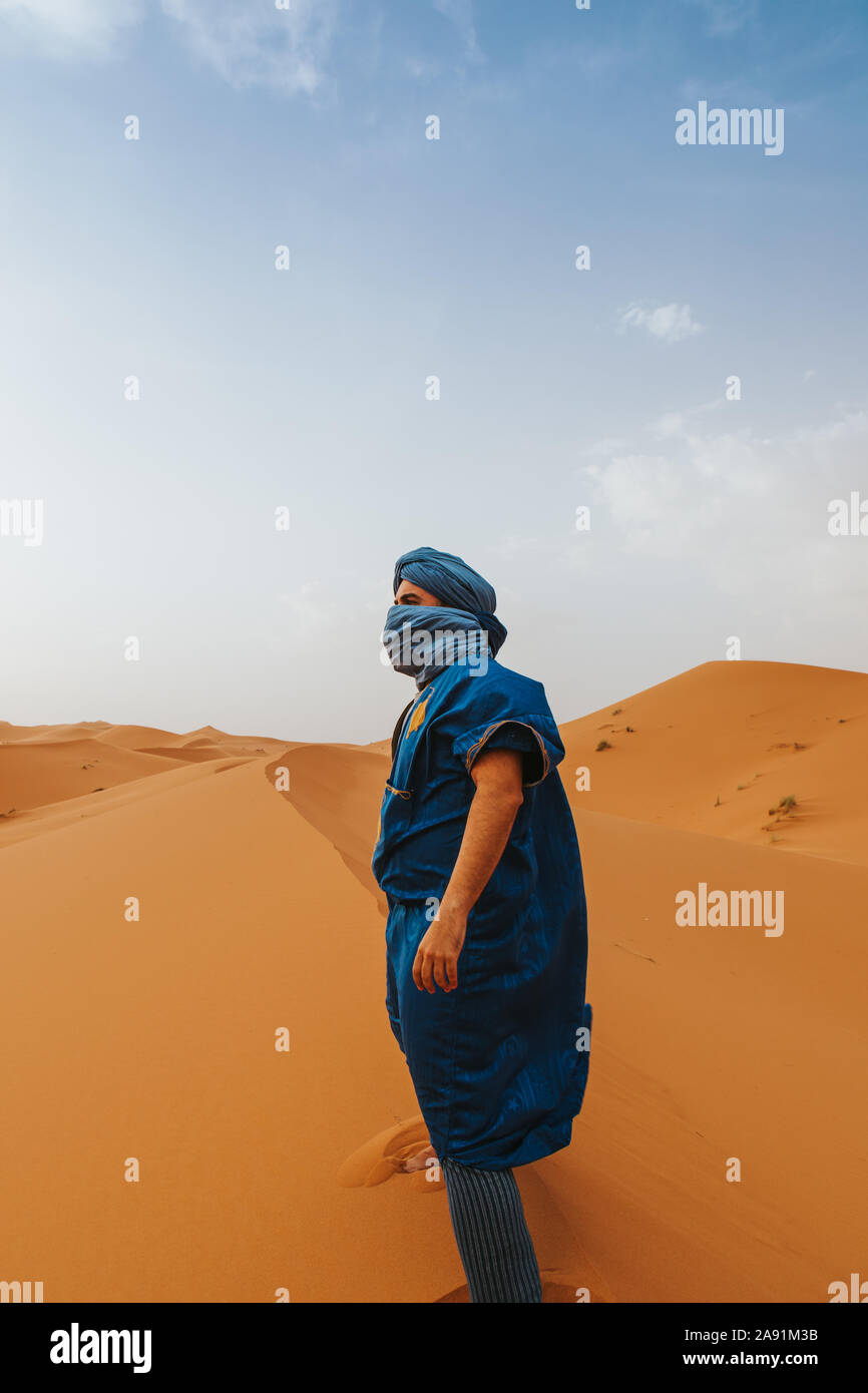 L'uomo con il classico riff vestiti in piedi sulle dune del deserto da soli. Foto Stock
