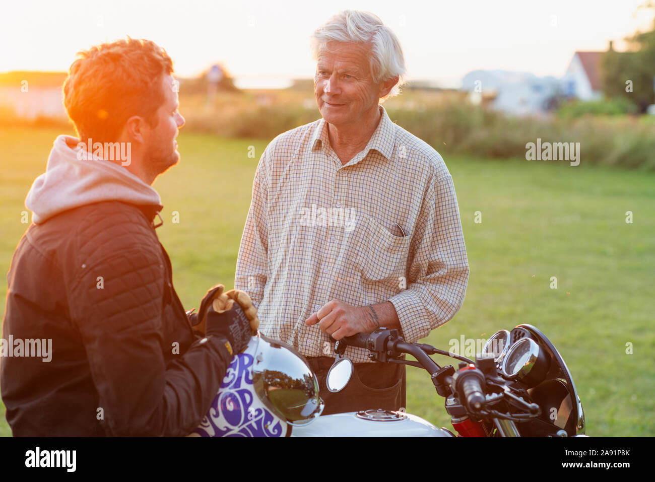 Padre con figlio adulto parlando Foto Stock