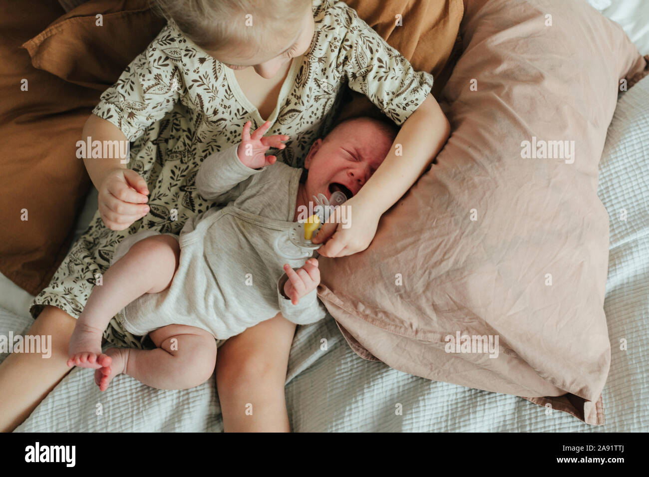 Ragazza con i gemelli neonati sul letto Foto Stock