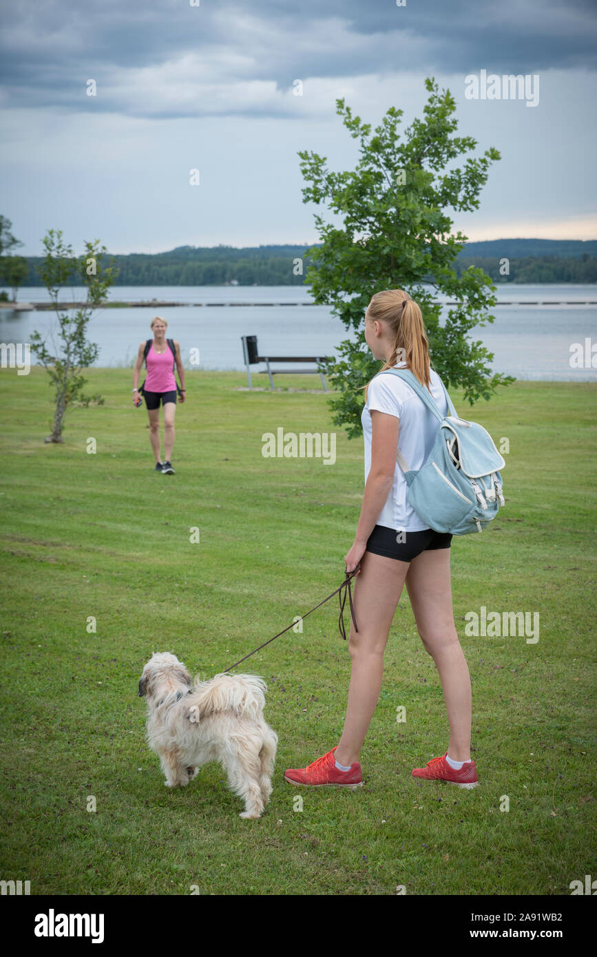 Giovane donna tenendo il cane al guinzaglio Foto Stock