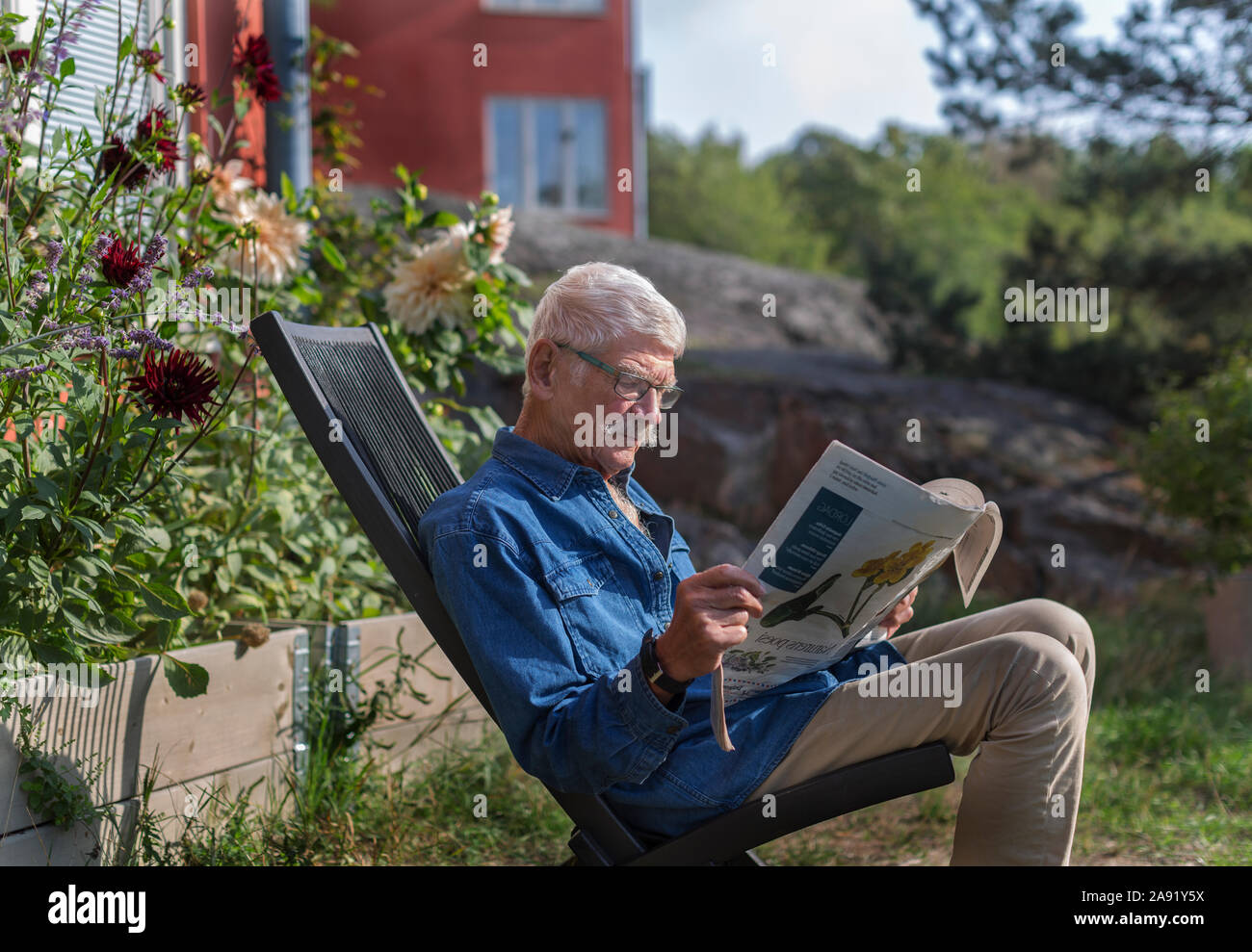 L uomo nel giardino quotidiano di lettura Foto Stock