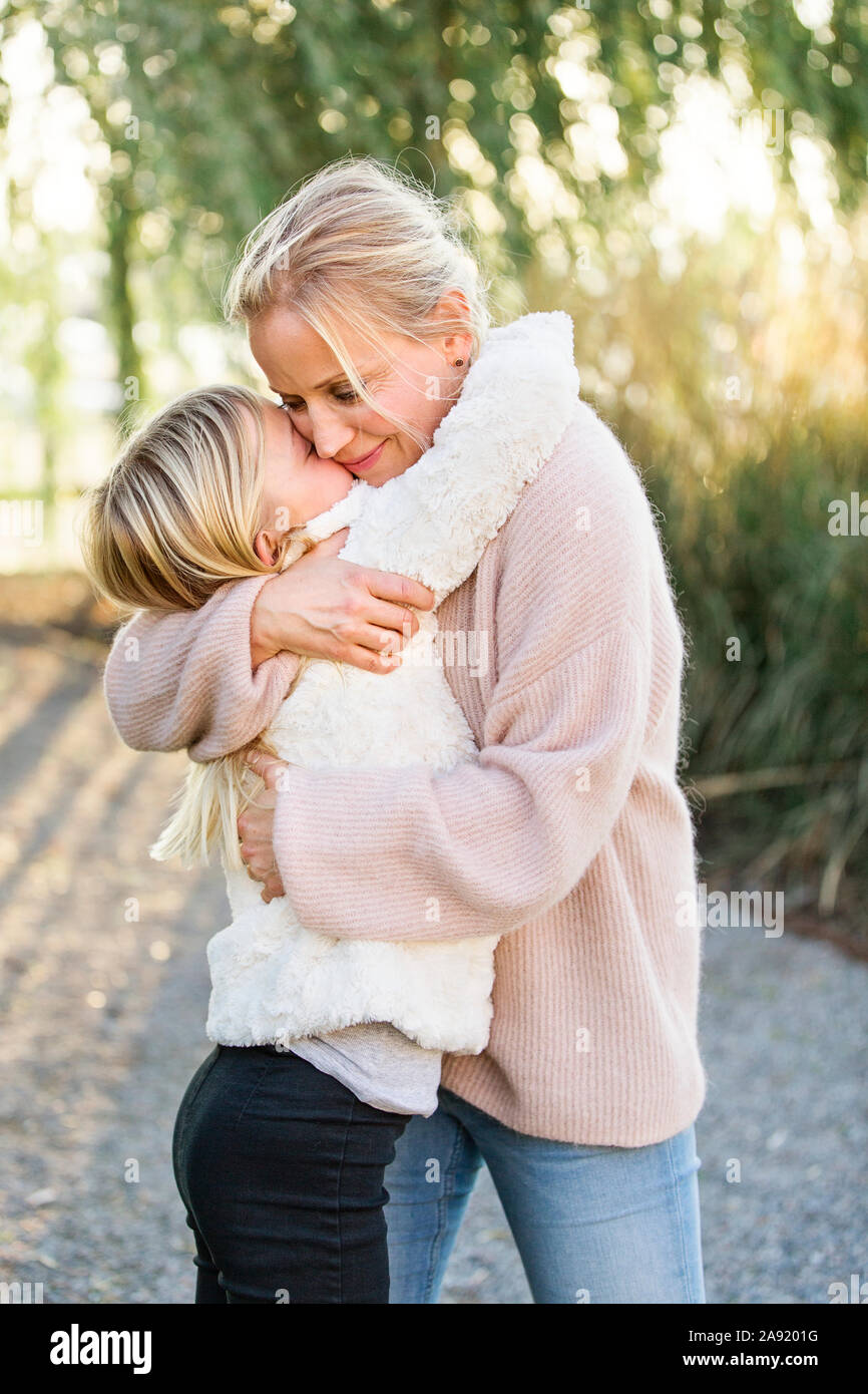 La madre abbraccia la figlia Foto Stock