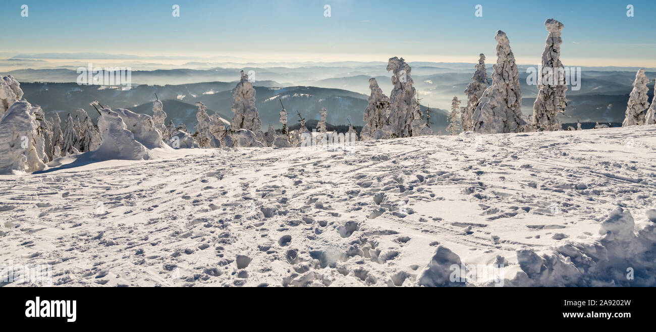 Vista dal Lysa Hora hill in inverno le montagne di Moravskoslezske Beskydy in Repubblica Ceca con molte colline, congelati alberi e cielo chiaro Foto Stock