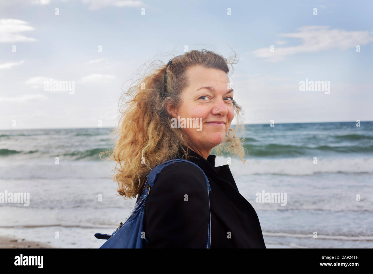 Donna sorridente al mare Foto Stock
