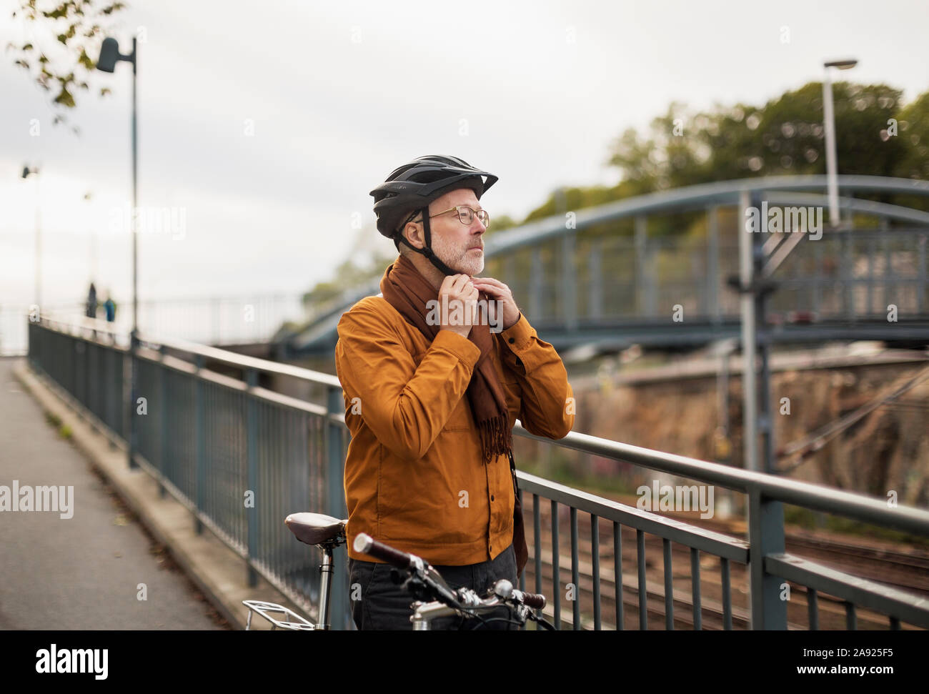 Uomo di mettere il ciclismo casco su Foto Stock