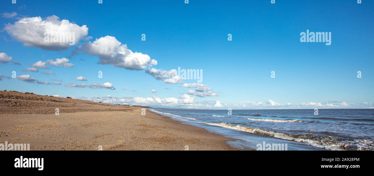 Le nuvole in un cielo blu sulla costa Foto Stock