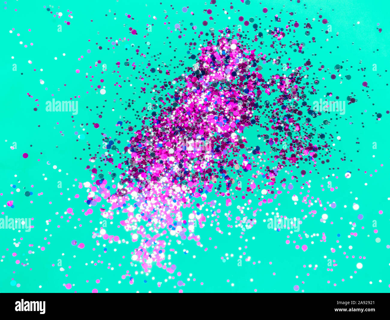 Festive neo superficie di menta con spumante viola e azzurro coriandoli. Lay piatto. Foto Stock