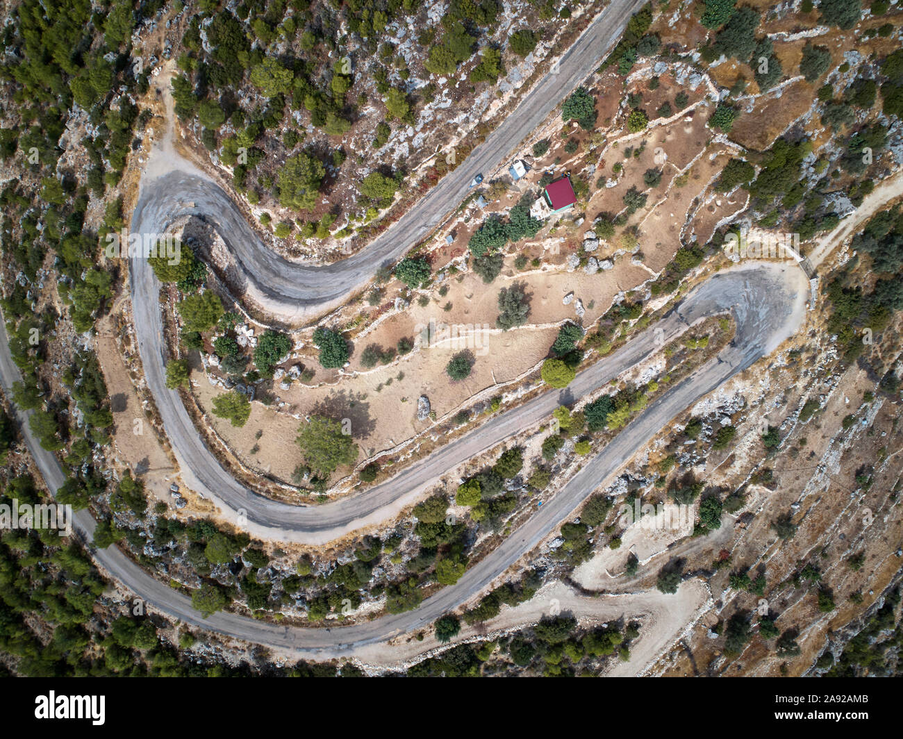 Un avvolgimento della serpentina di montagna strada asfaltata. Top down vista aerea. Foto Stock