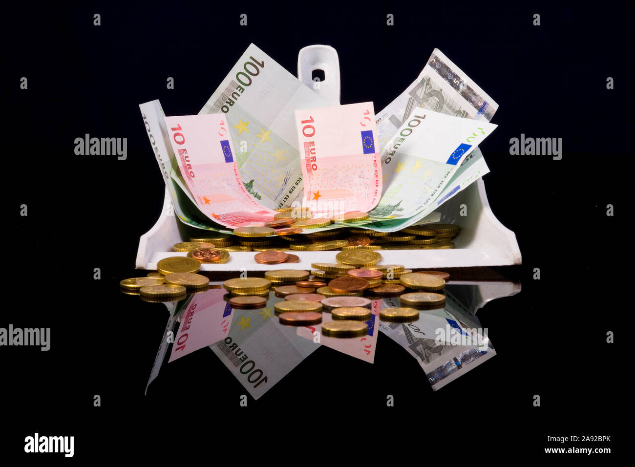 Euro Geld in einer Kehrschaufel, und Münzen Banknoten, Foto Stock