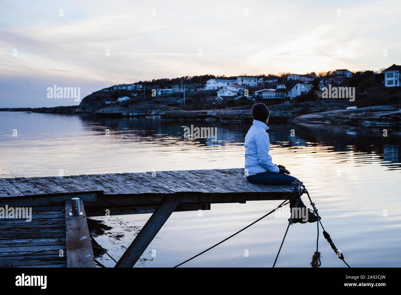 Donna seduta sul molo Foto Stock