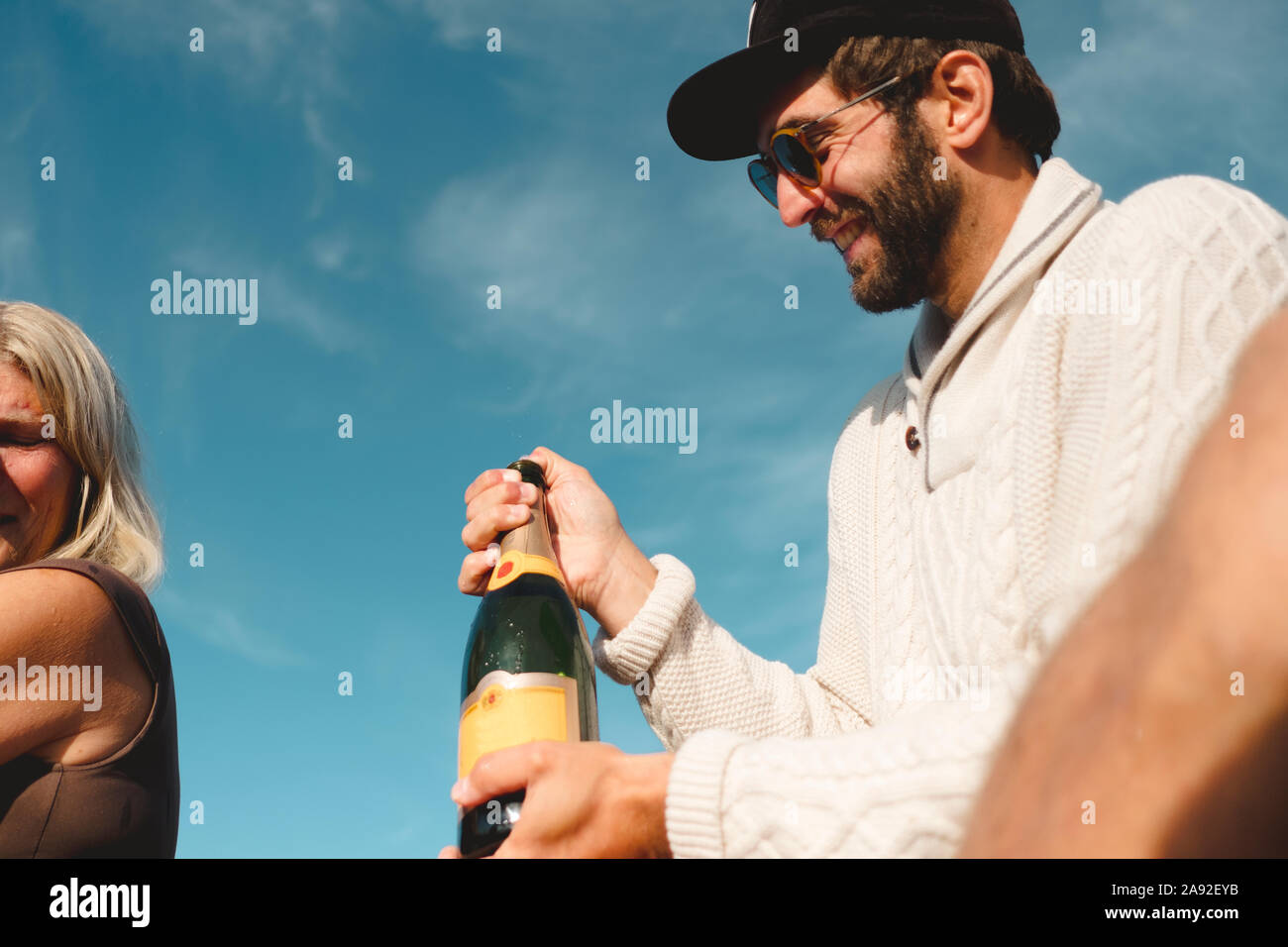 Uomo sorridente tenendo la bottiglia di champagne Foto Stock