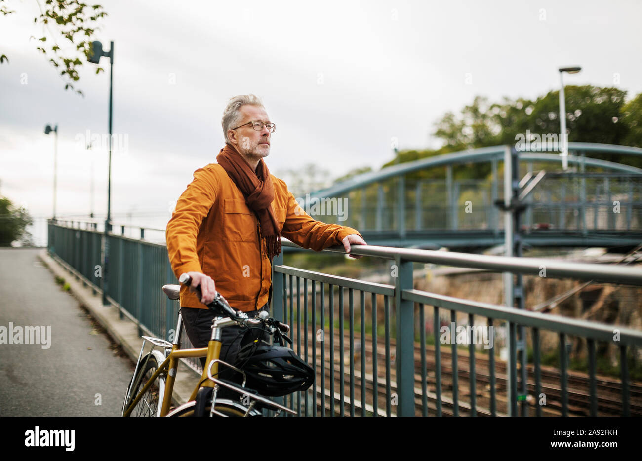 L'uomo con la bicicletta in piedi sul ponte Foto Stock