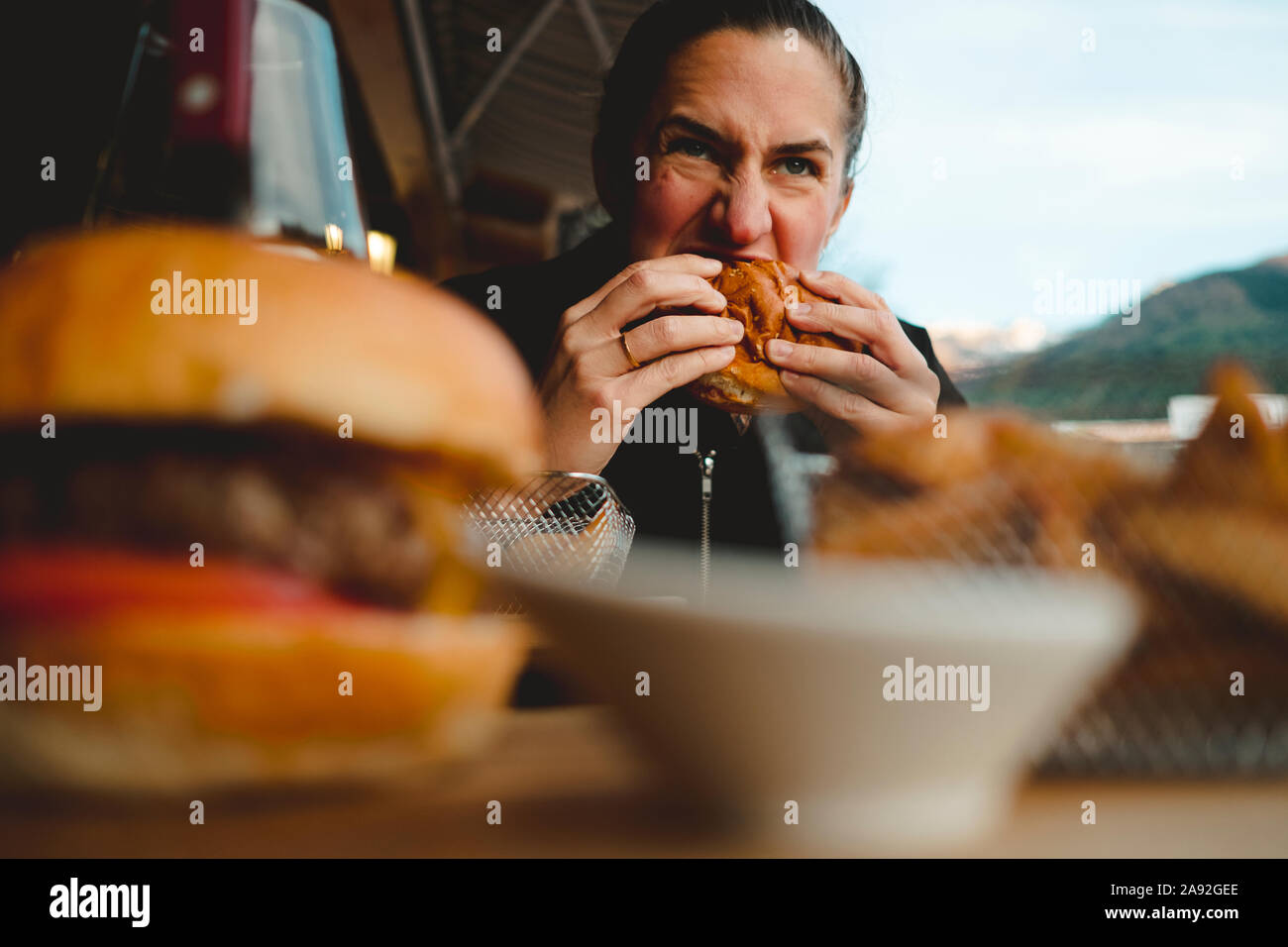 Donna con burger Foto Stock