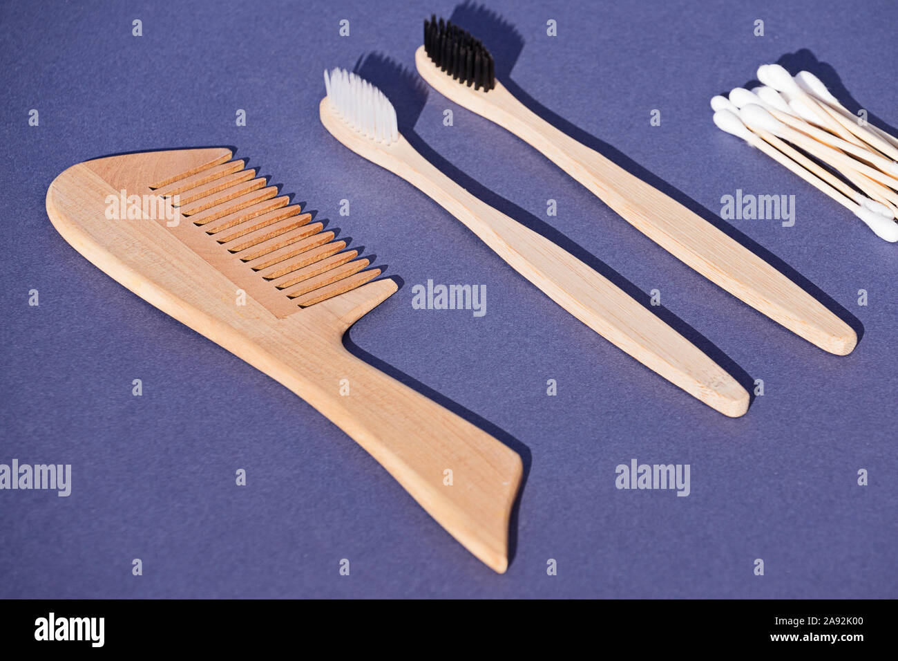 Set di spazzola in legno, spazzolino da denti e batuffoli di cotone realizzato a partire da fonti rinnovabili, biodegradabile e materiali riciclabili di bambù su sfondo blu Foto Stock