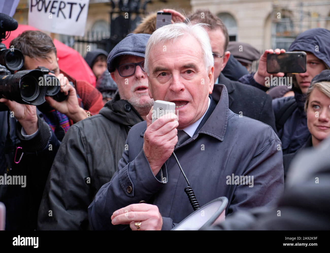 Westminster, Londra, Regno Unito. 12 novembre 2019. John McDonnell, manodopera MP e ombra il Cancelliere dello Scacchiere rivolgendosi al McDonalds dipendenti dalla regione di Londra colpisce nella parte anteriore del 10 Downing strade riforme promettenti come parte di un governo laburista di aumentare i salari minimi e proteggere i tassi dei lavoratori poveri. Cartello con la 'Povertà' in background Credito: JF Pelletier / Alamy Live News Foto Stock